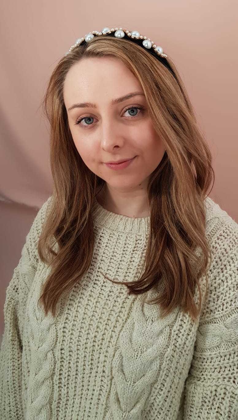 Trend on trial: Woman with blonde wavy hair wearing a pearl headband and white knitted jumper.