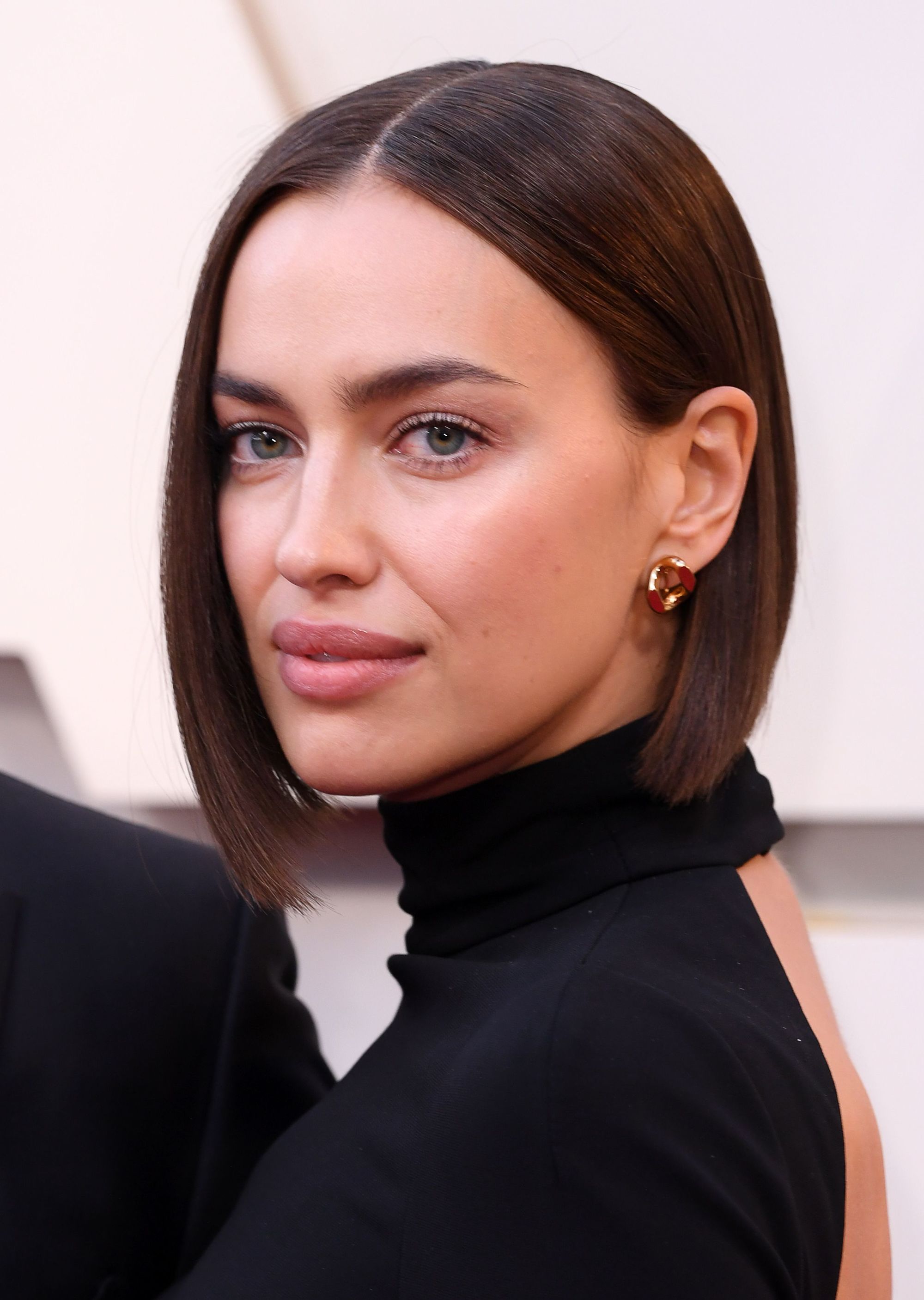 Spring haircuts: Irina Shayk at the Oscars with a short blunt dark brunette bob, wearing a high neck backless black dress