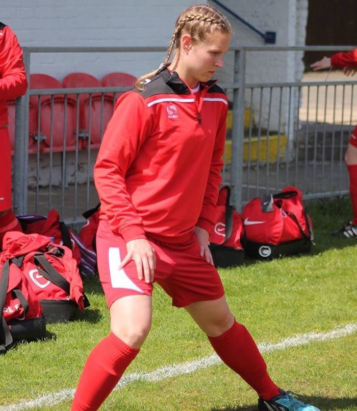 Working It: woman with blonde dutch boxer braids hairstyle wearing red football kit.