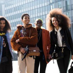 Group shot of women with natural hair laughing and posing outside a building