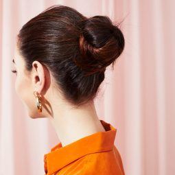 Woman with dark brown hair styled into a bun updo