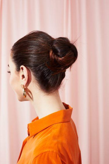 Woman with dark brown hair styled into a bun updo