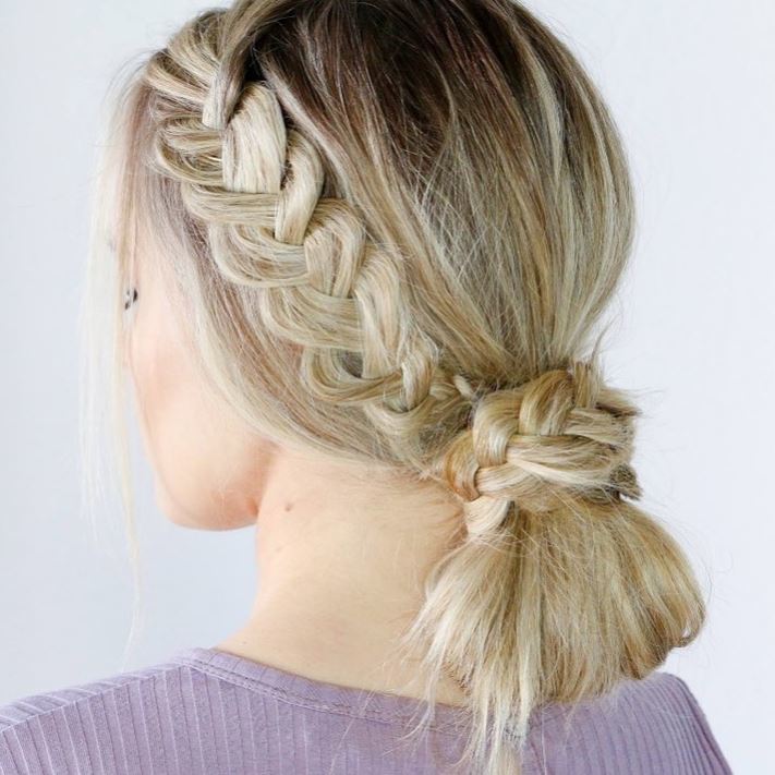 Blonde woman with straight hair in a low bun with side braid
