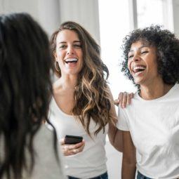 Power your presence with TRESemmé: A bunch of women with different hair types, one with wavy hair and the other with an afro, together and enjoying a touching moment