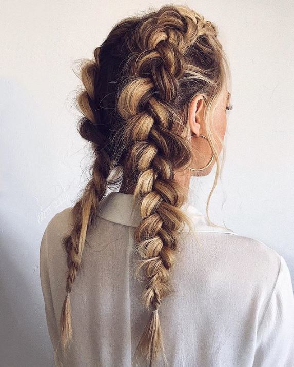 Woman with long dark blonde hair in double dutch braids