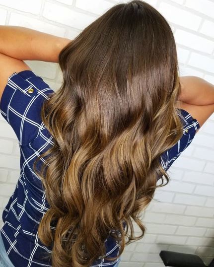 Woman with caramel ombre long wavy hair