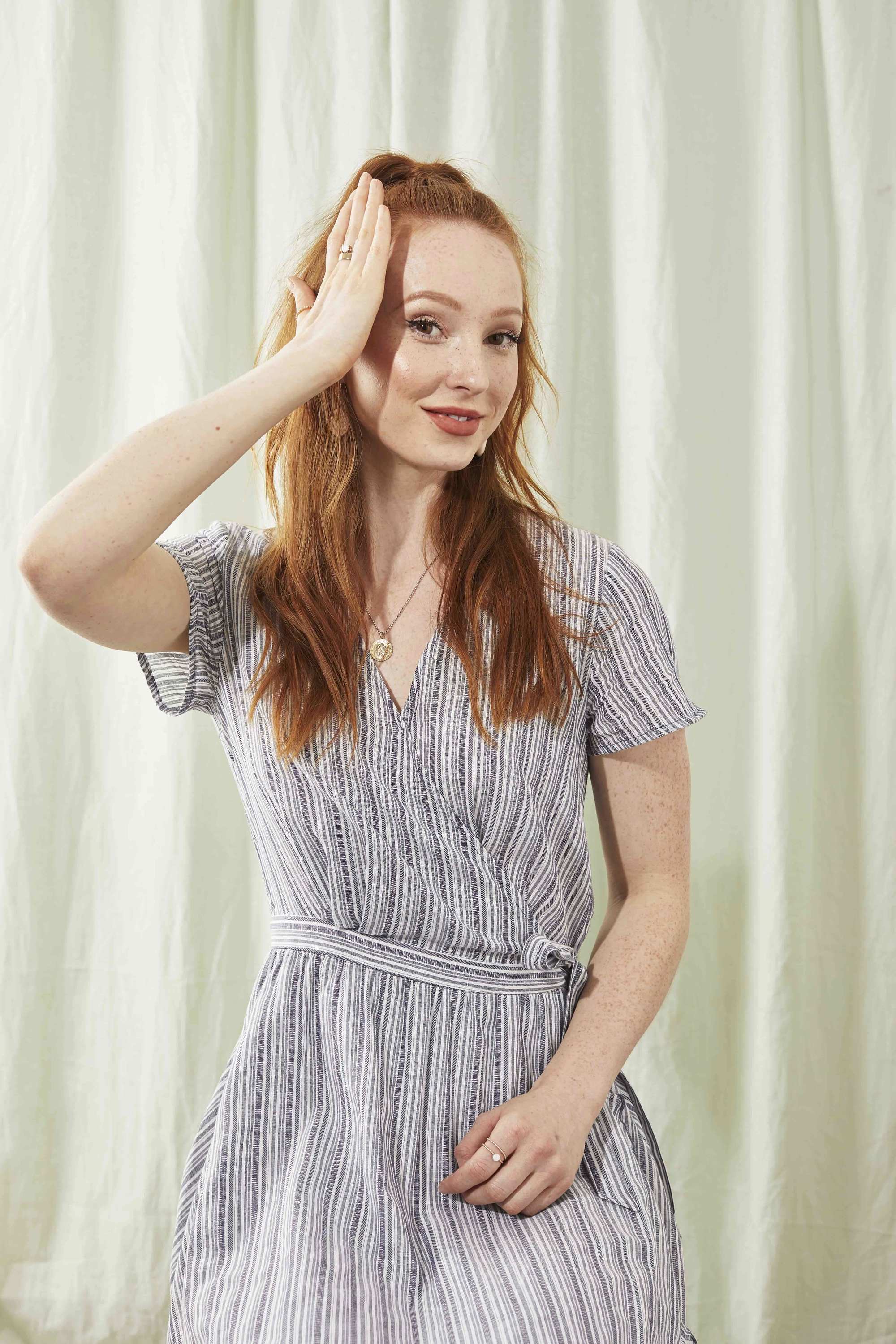 Redhead woman smoothing her hair with her hand
