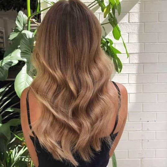 Woman with long light brown wavy ombre hair