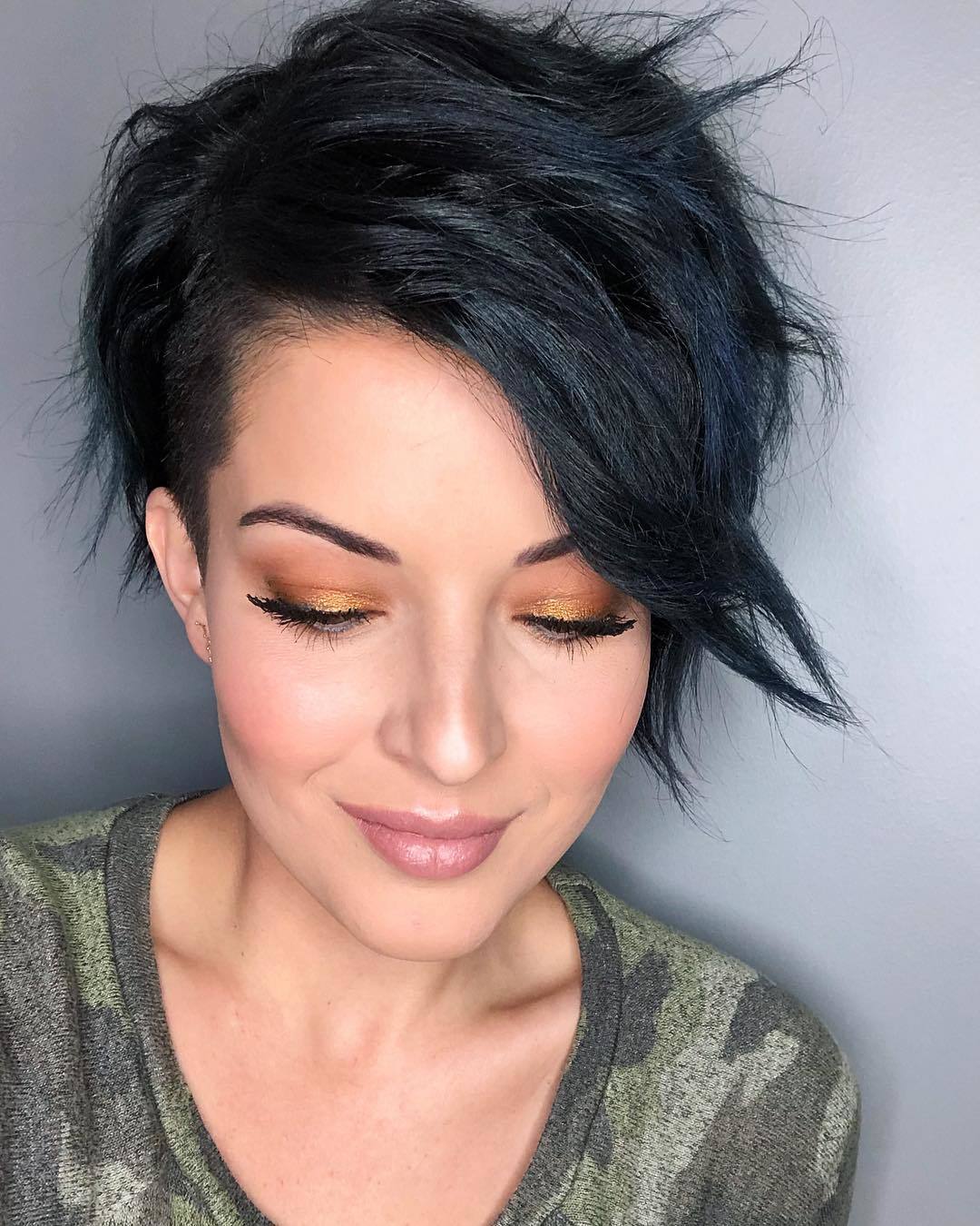 woman with dark brown side swept long bangs and pixie cut