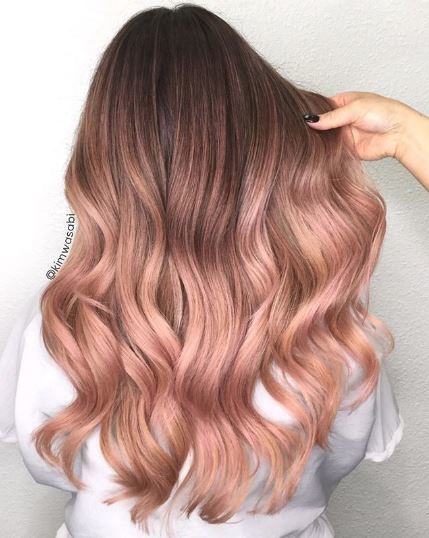 Woman with rose gold wavy ombre hair
