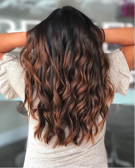 Woman with auburn highlights on long dark brown hair