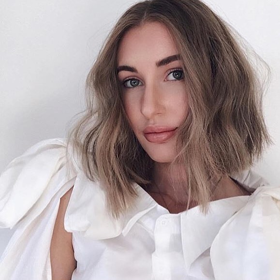 woman with ash brown short hair styled into heatless beach waves