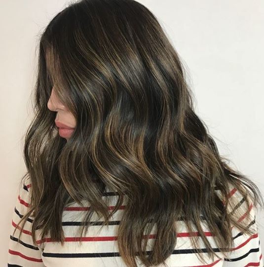 Woman with highlights on dark brown wavy hair