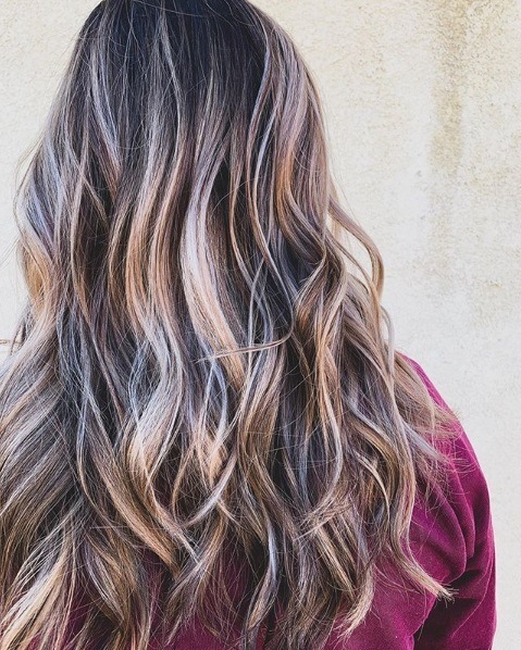 Woman with long wavy blonde hair with brunette lowlights