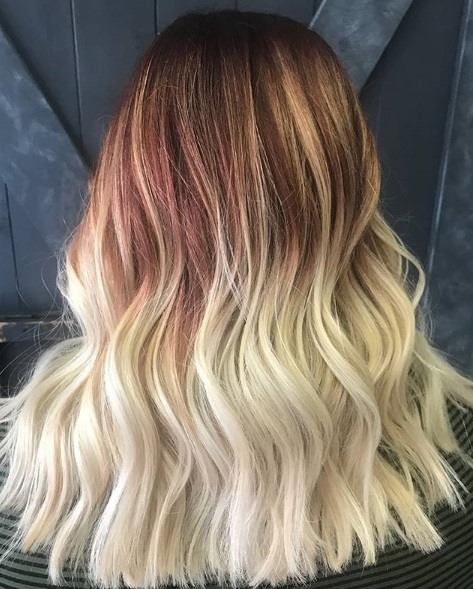Woman with wavy red to blonde ombre shoulder length hair