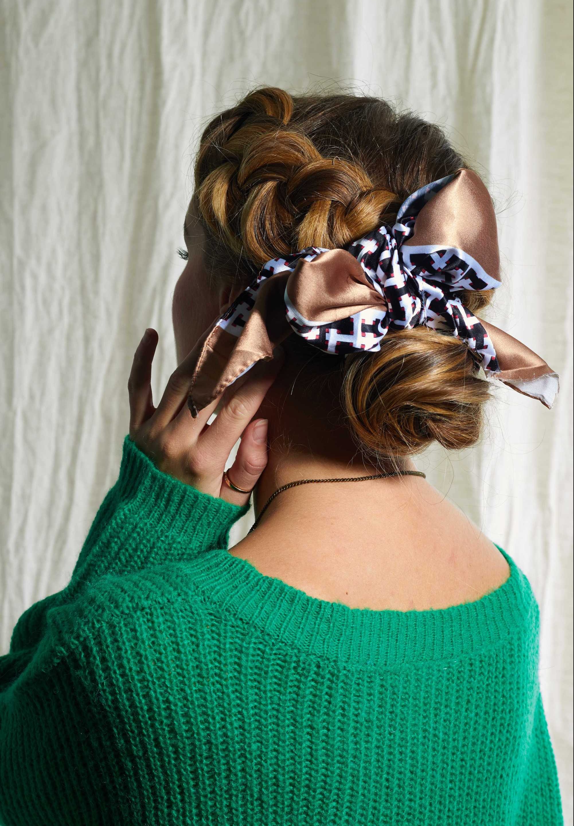 Woman with blonde hair in side braid bun.