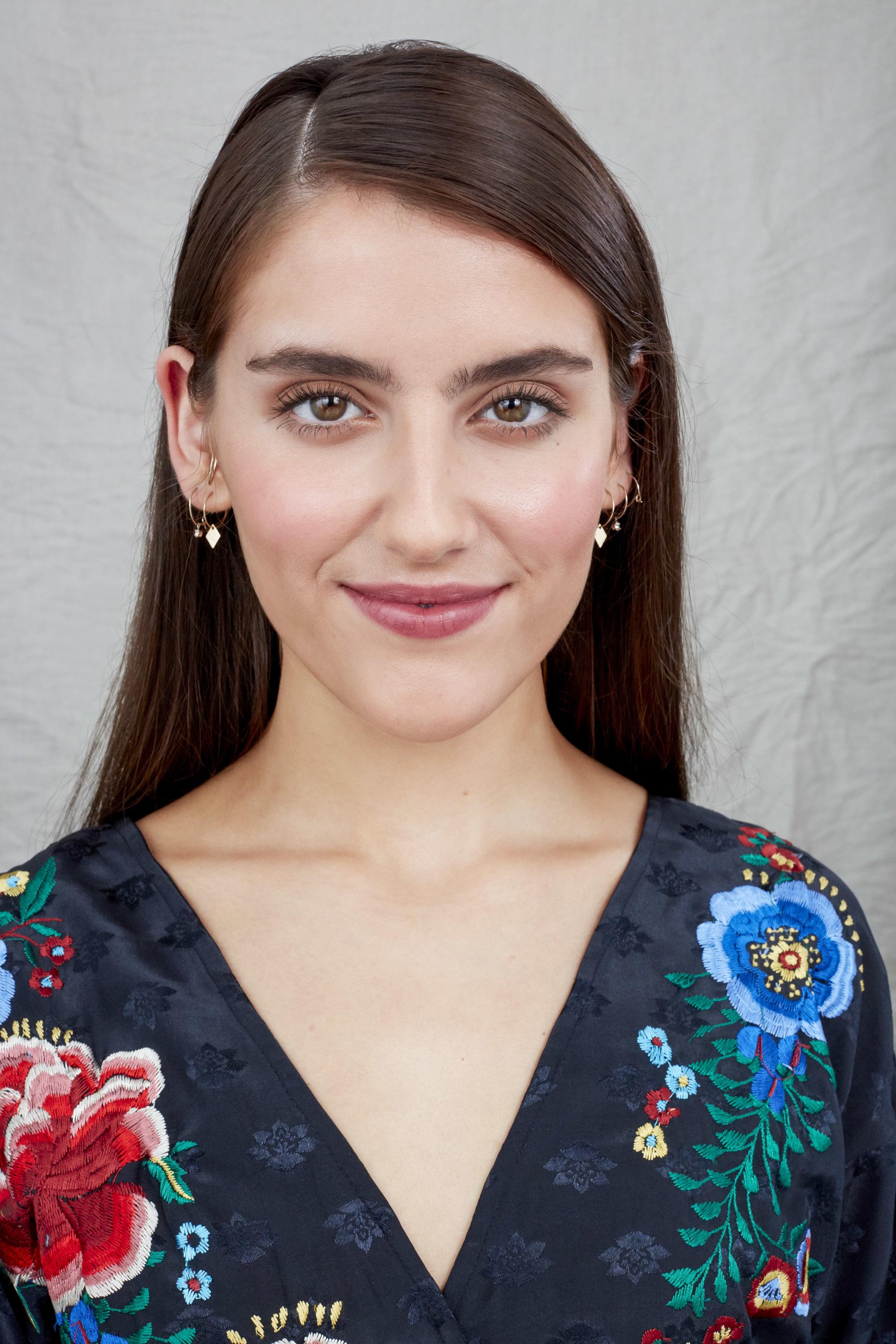 Woman with long straight brown hair in side parting