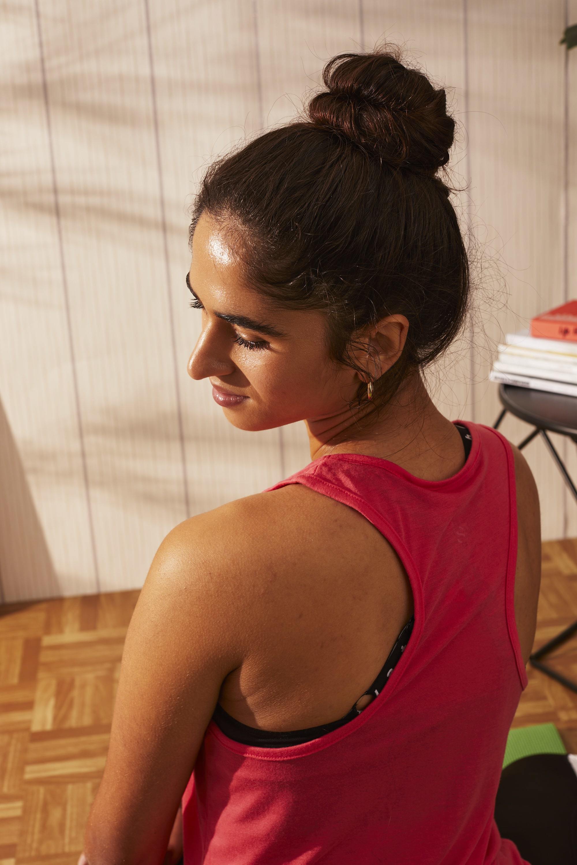 Woman with brown hair styled into a top knot