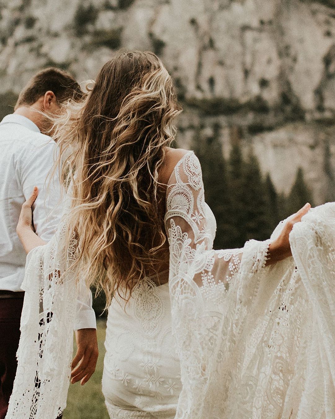 woman wearing a wedding dress with bronde long messy beach waves hair