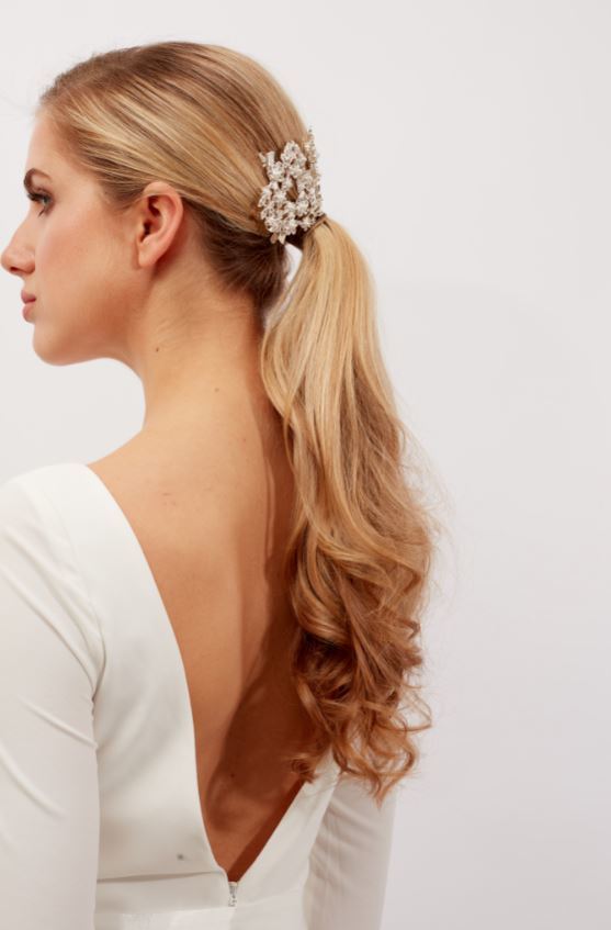 Woman with long blonde hair in ponytail withwavy ends