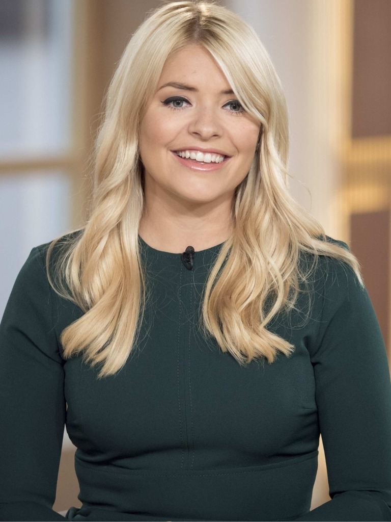 Holly Willoughby hair gallery: Holly Willoughby with long blonde wavy hair in side parting with swooping side fringe wearing a teal dress.