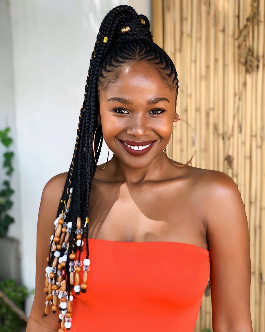 Woman with long cornrow ponytail with beads