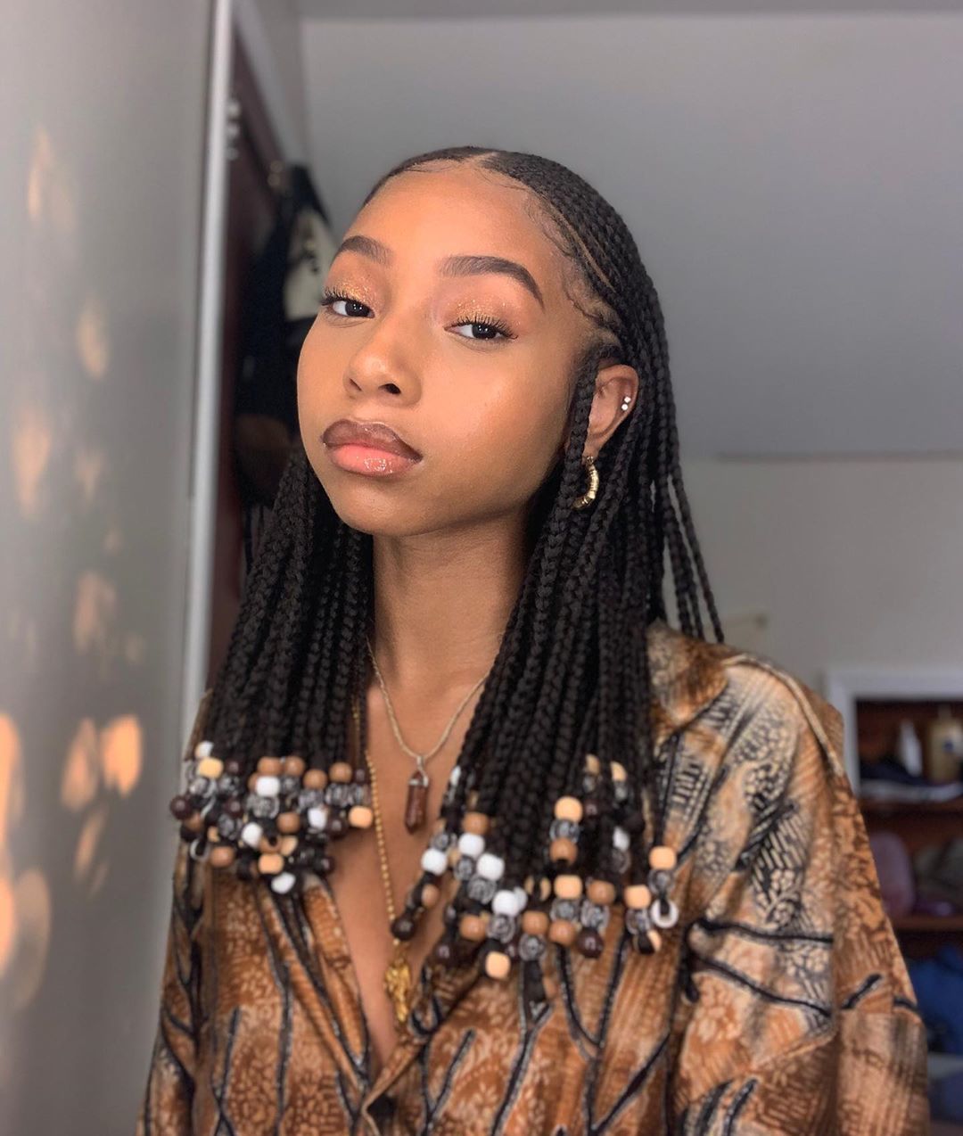 Woman with medium length cornrows with beads