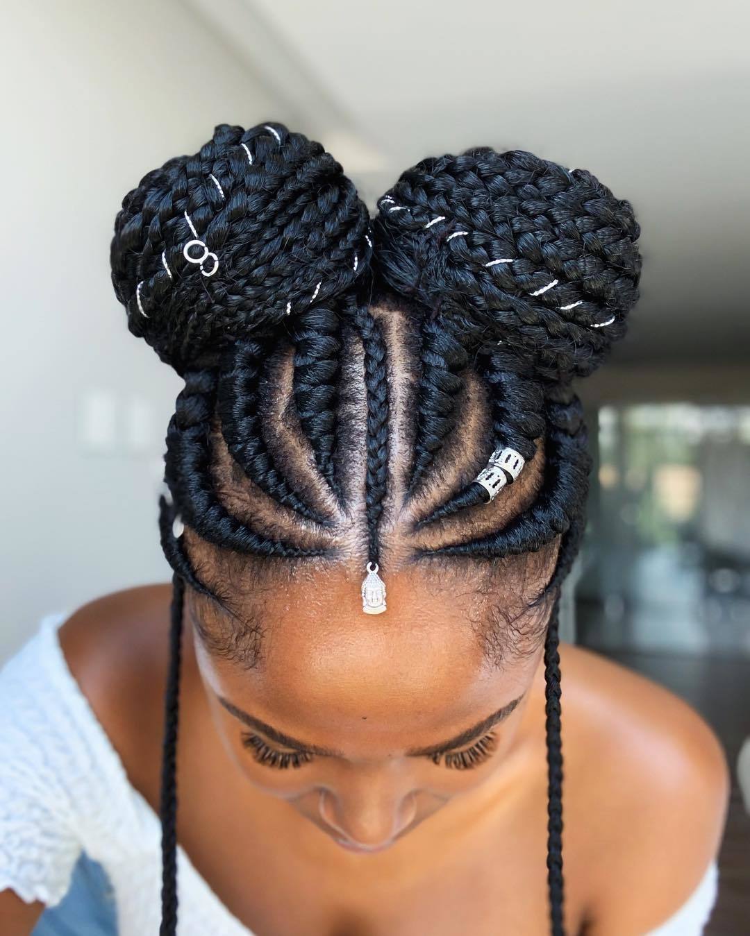 Woman with dark banana cornrows double bun updo