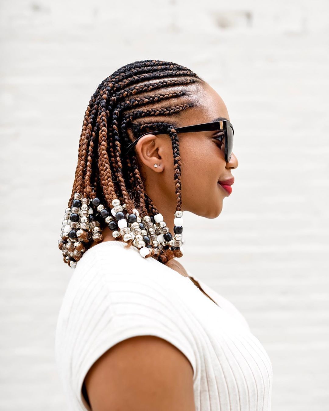 Woman with shoulder length cornrow hairstyle with beads