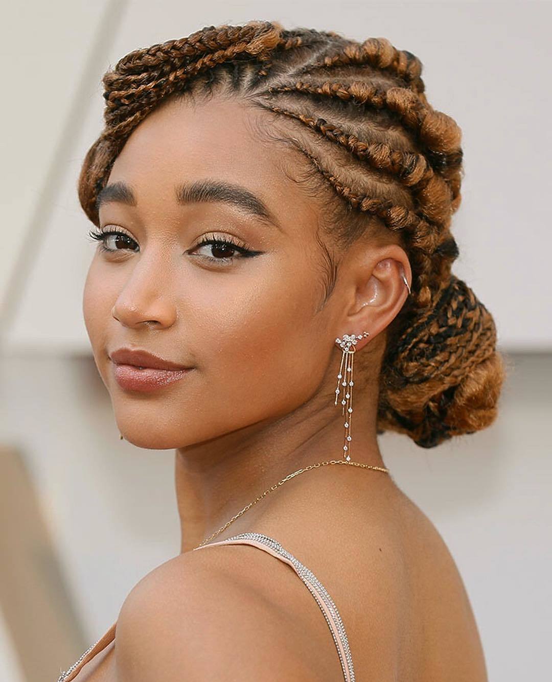Amandla Stenberg with low braided cornrow updo on the red carpet