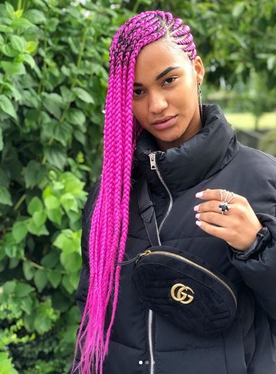 Woman with long pink cornrows to the side