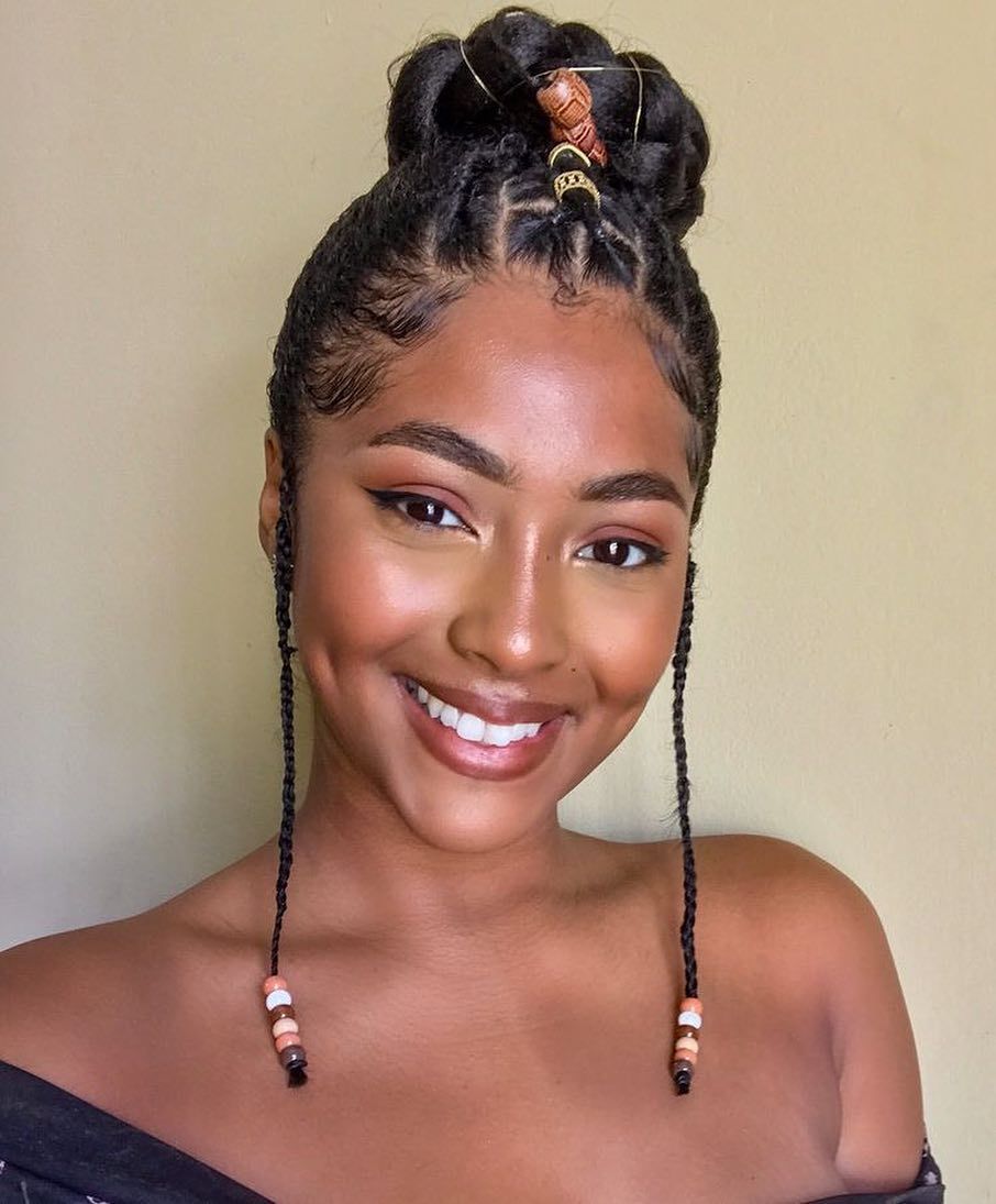 Woman with cornrow braided bun with beads and golden hair thread