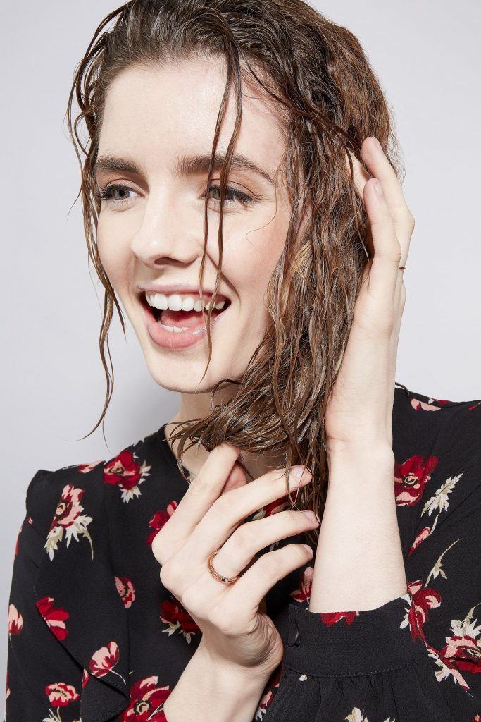 Woman touching her curly wet hair