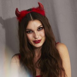 Woman with long dark brown hair with devil horns