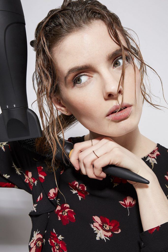 Woman blow-drying wet hair