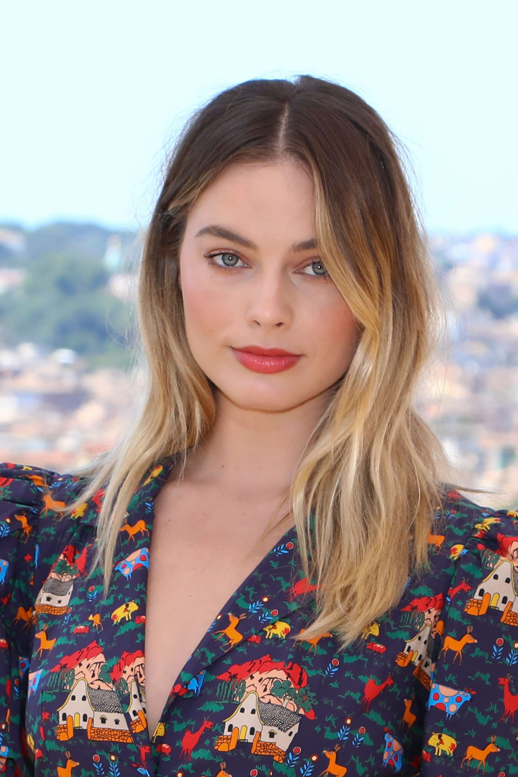 Margot Robbie with brunette to blonde hair with grown-out roots