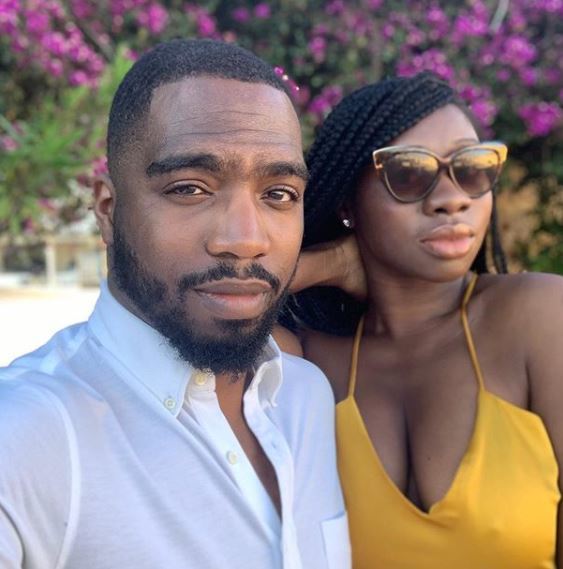 bearded black man posing with a black woman in yellow dress