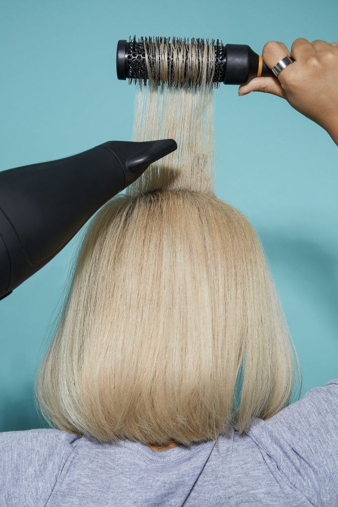 Woman blow-drying blonde bob