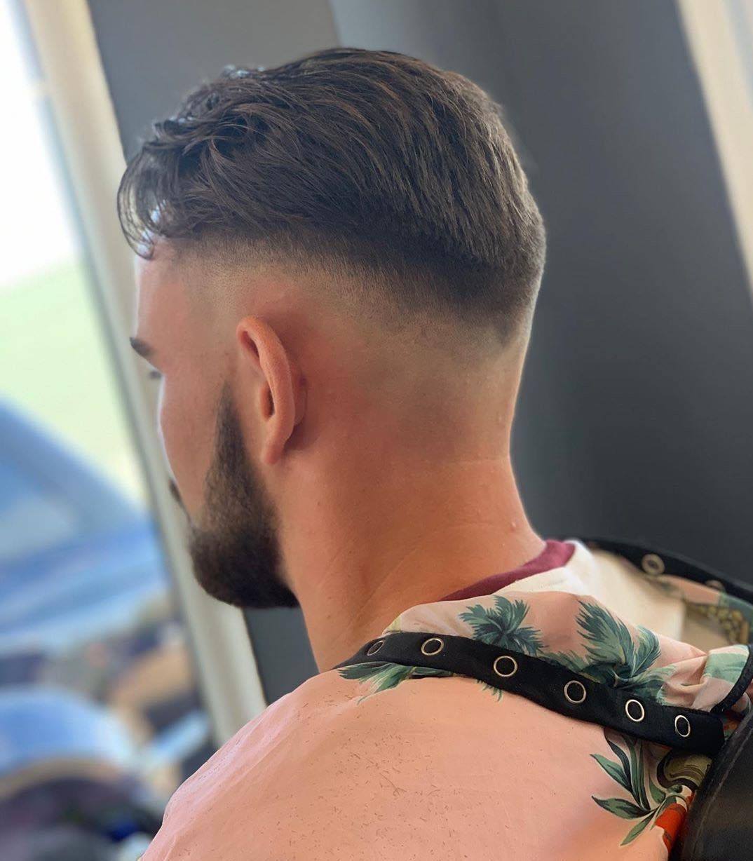 Man with v shaped fade haircut with slick hair