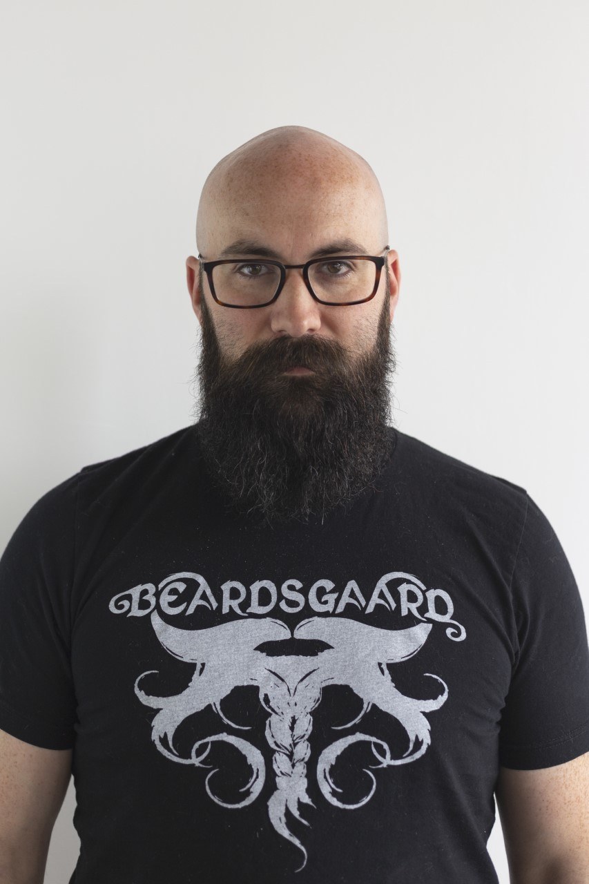 Man with bald head and beard wearing glasses