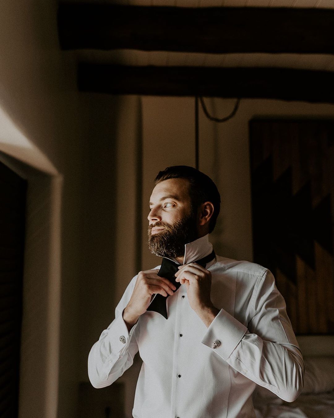 Man with dark hair and beard wearing a suit