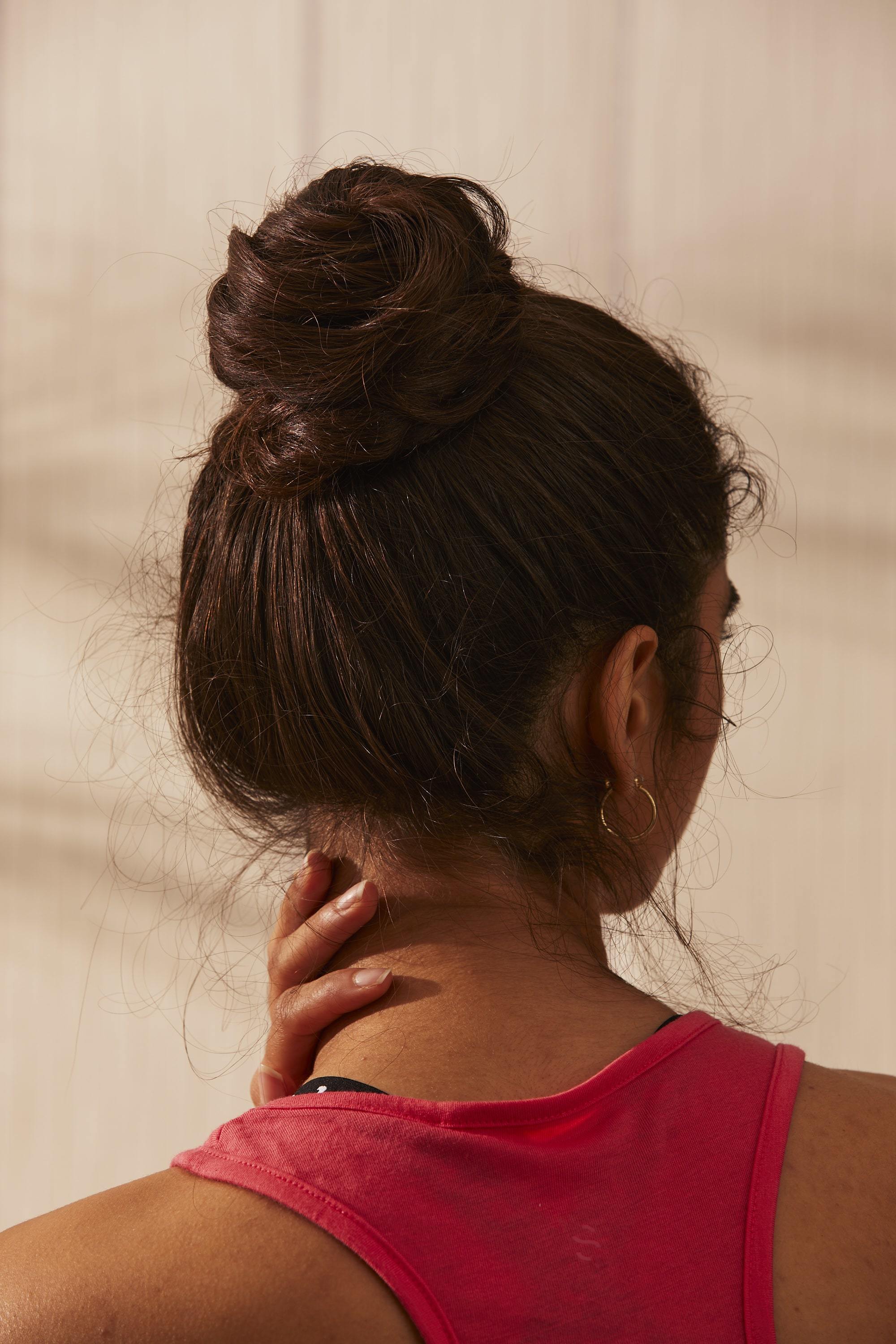 Woman with dark hair styled into a top knot