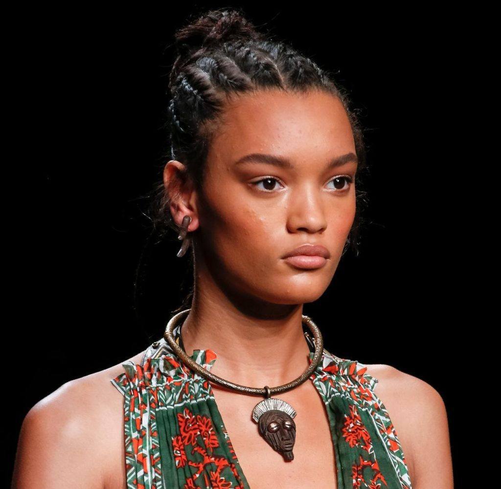 Woman with brown hair in cornrows