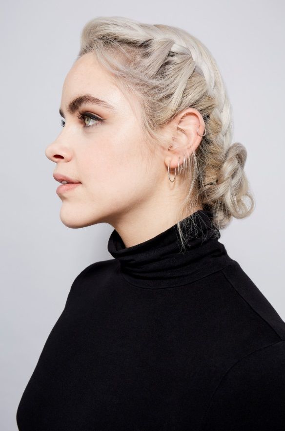 Woman with platinum blonde hair in a French braided bun