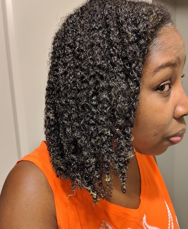 Woman with wet coily natural hair with a hair mask in