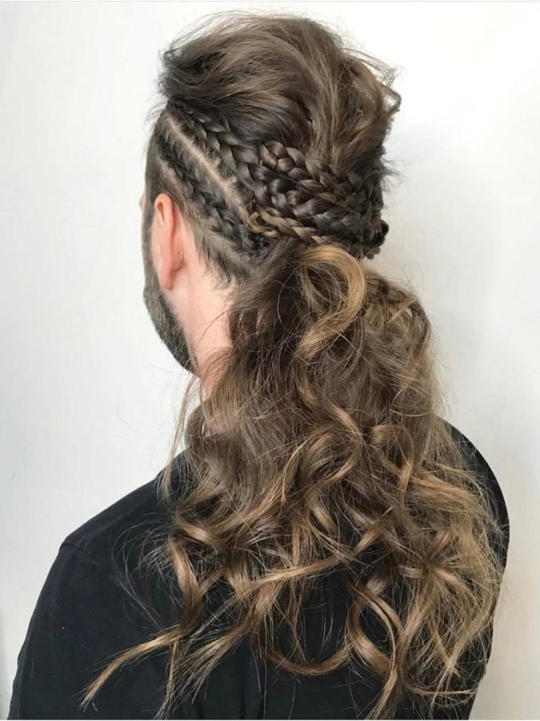 Brown haired man with a braided curly ponytail updo