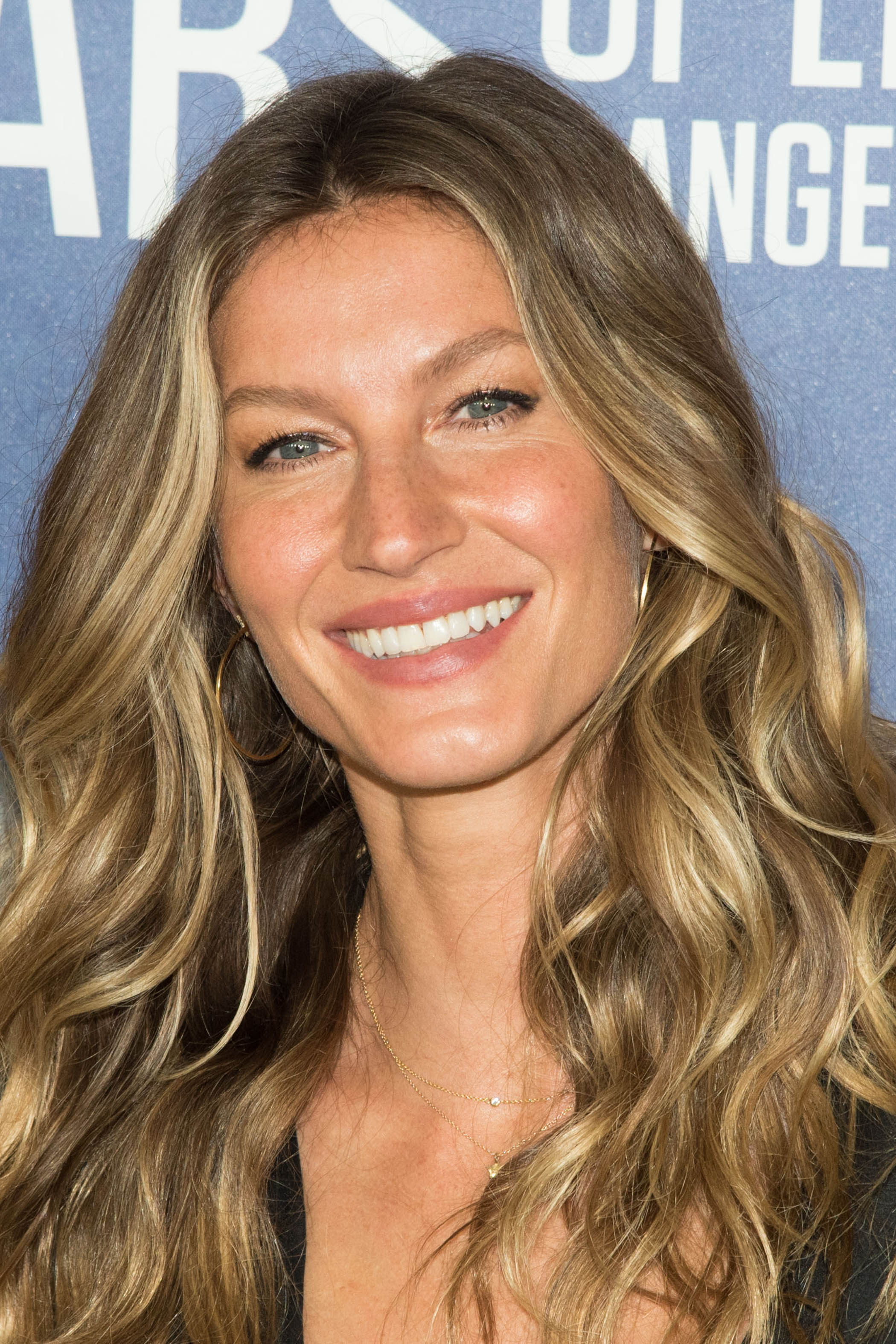 Gisele Bündchen with dark blonde hair and sandy face-framing highlights