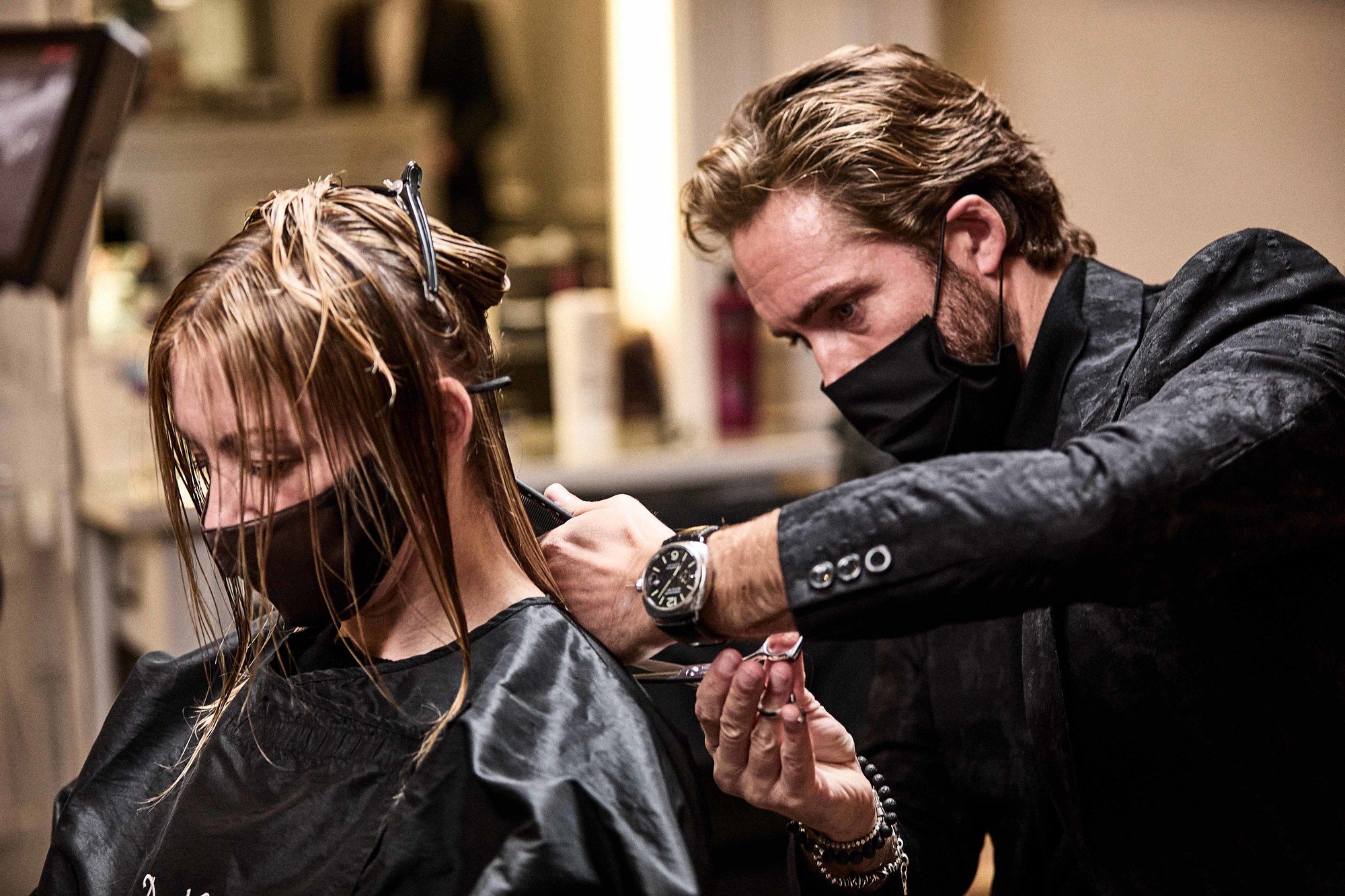 Hair stylist James Brunt cutting a blonde woman's hair