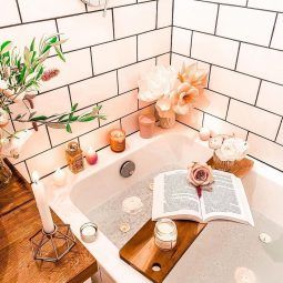 Photo of a bath with relaxing candles and a book