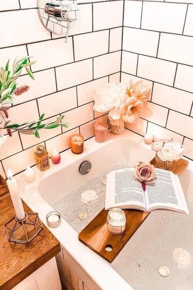 Photo of a bath with relaxing candles and a book